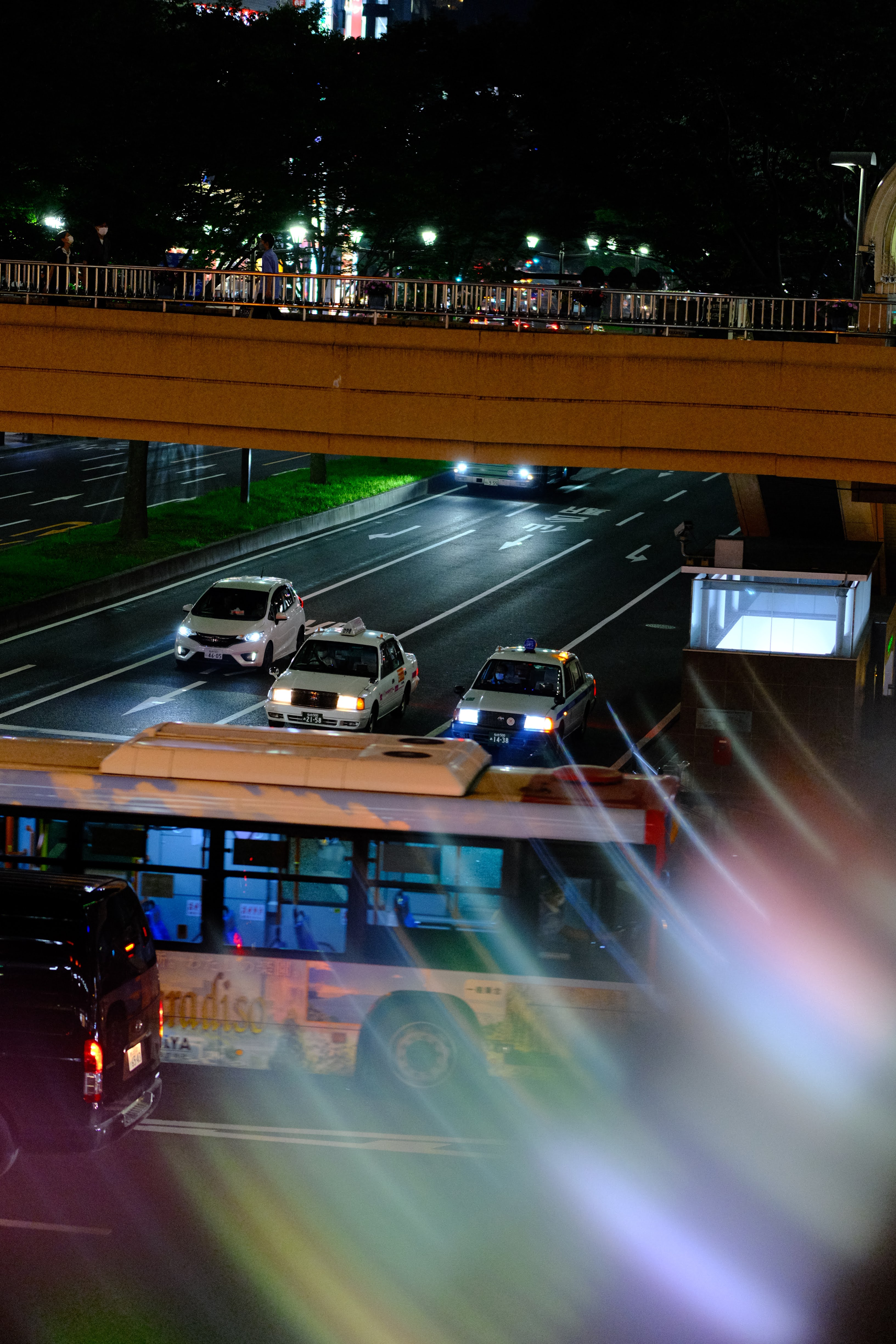 夜の都市を高い位置から俯瞰した風景。道路を走る車のライトが流れ、街の光が広がる夜景写真